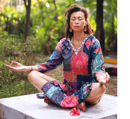 darmowe-wyzwanie-rok-z-ajurweda_edyta-sicinska Edyta Sicińska podczas medytacji w kolorowej tunice siedzi po turecku układając dłonie w mudry.